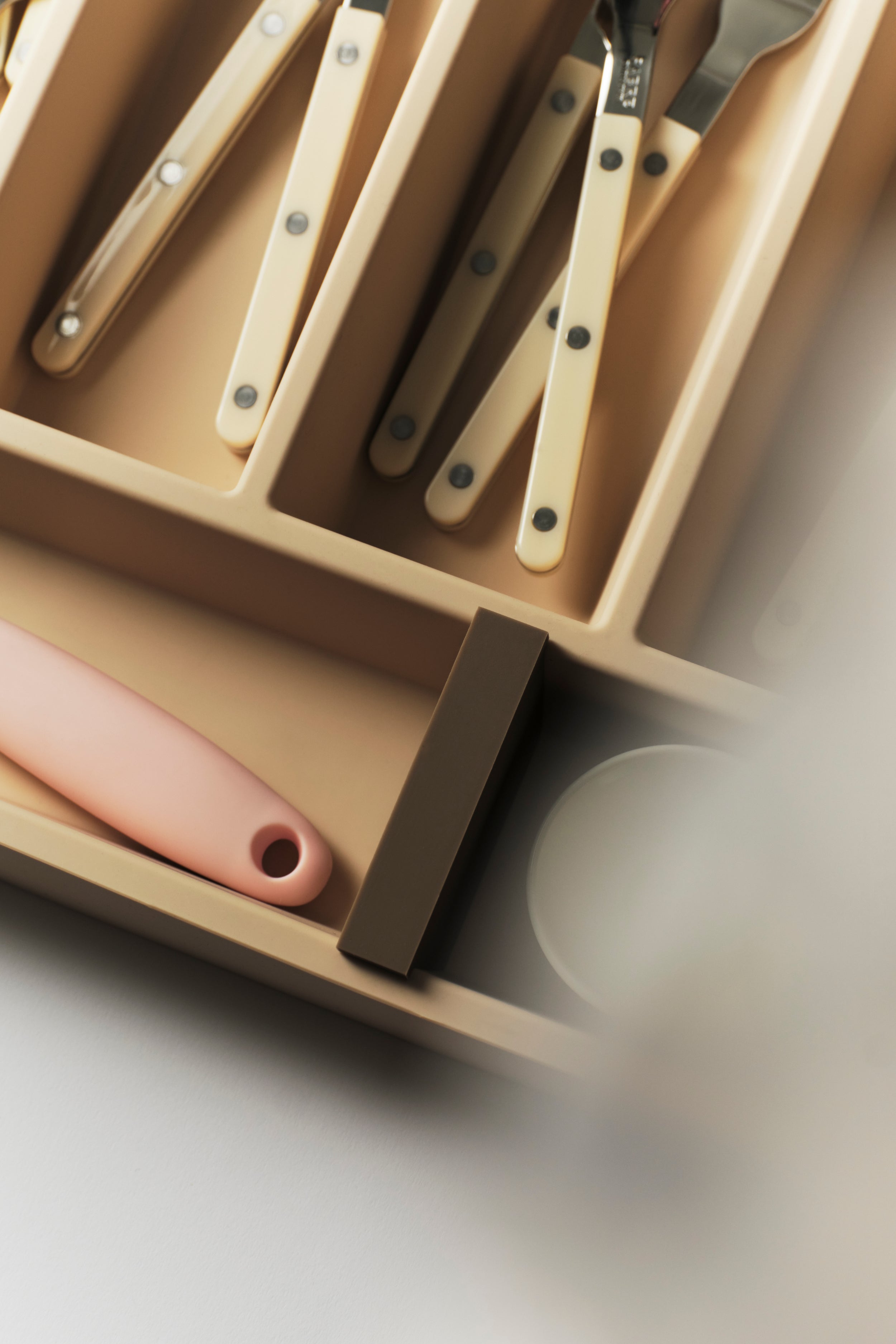 Close-up detail of the COMPARTMENTO Vide inlay's magnetic moveable dividers and smooth silicone finish